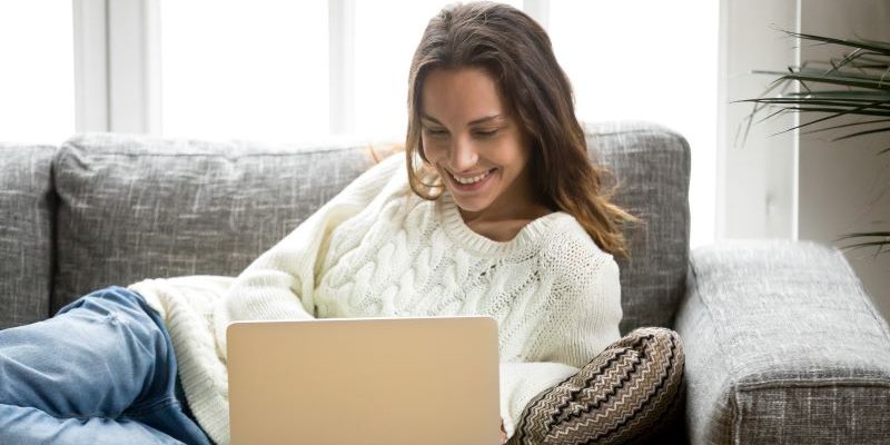 Student writing scholarship essay on laptop